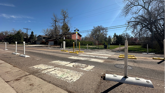 Curbs and flexible posts narrow the roadway at trail crossings